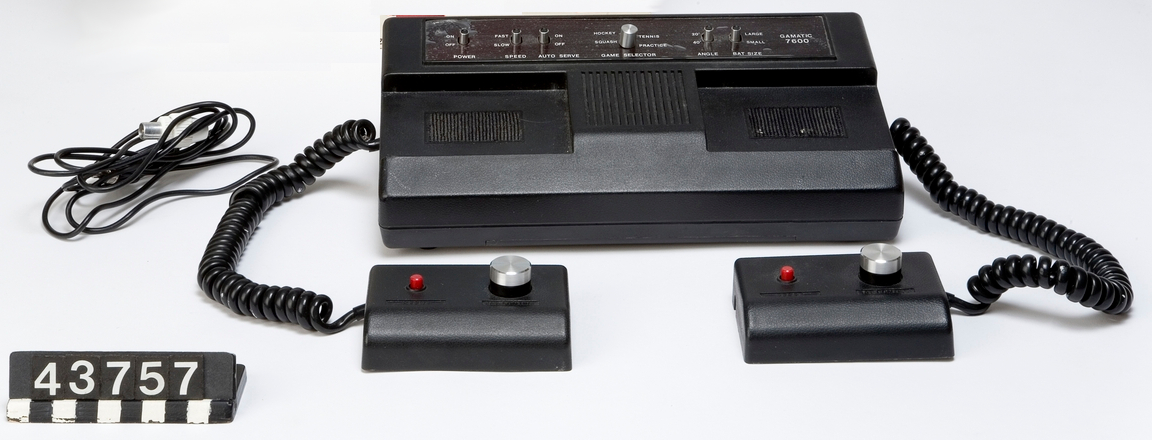 Vintage gaming console with controllers, isolated on a white background